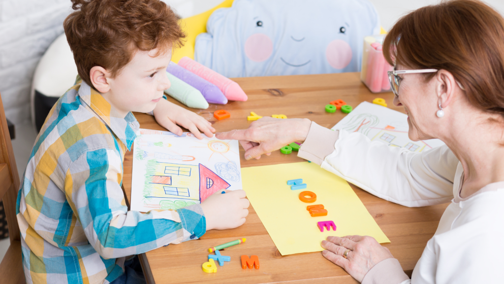 A woman and child sitting at a table, looking at a piece of paper together.