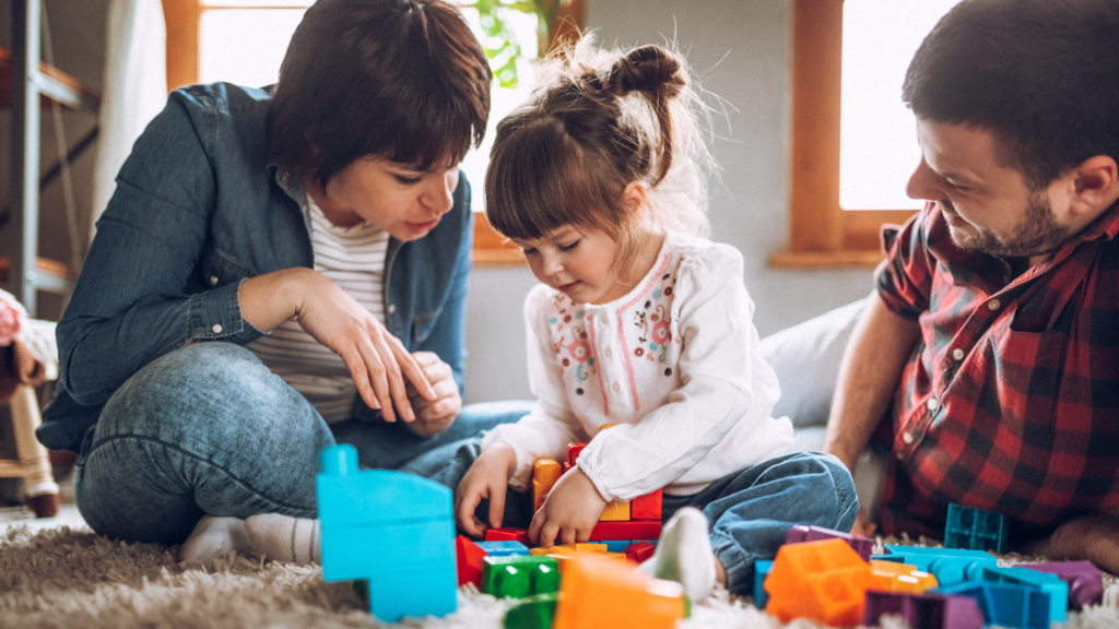 A family happily playing with toys on the floor, creating joyful memories together.